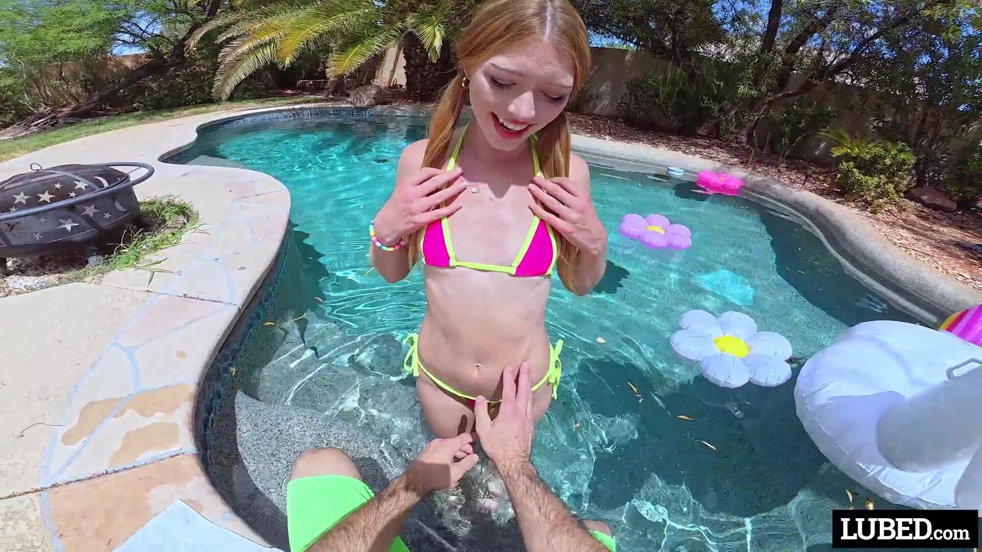 Pigtailed redhead teen frolics in the pool before getting fucked indoors